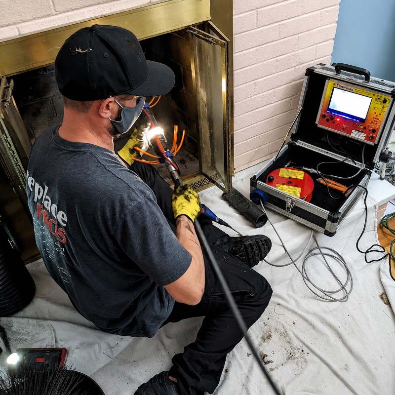 Chimney technician performing a visual inspection on a rooftop in Manhasset Hills