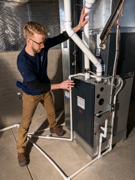 CSIA-certified technician performing carbon monoxide testing on a gas flue in Manhasset Hills